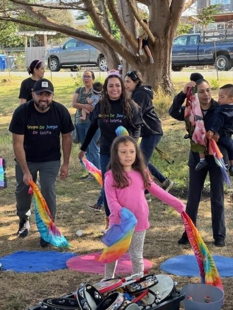 Children and caregivers dancing with ribbons